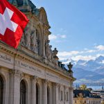 Swiss National Bank building with a Swiss flag and Alpine backdrop following the September 2026 policy-rate decision.
